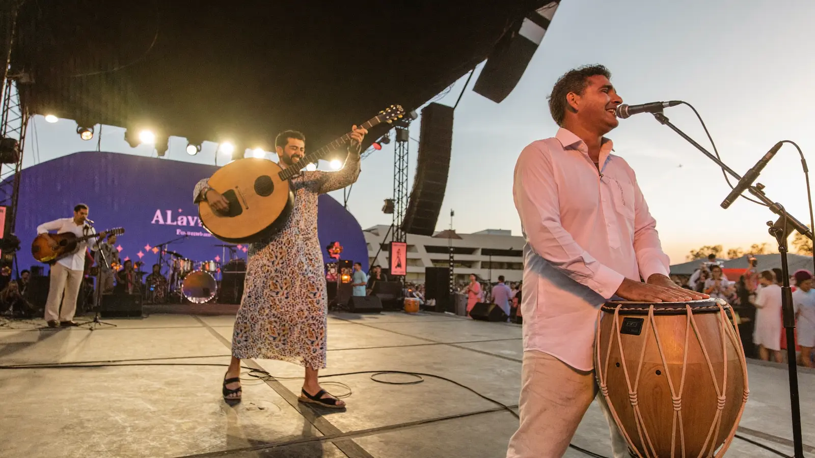 A musician playing the oud beside a derbake drummer performing live Lebanese music on stage at the festival